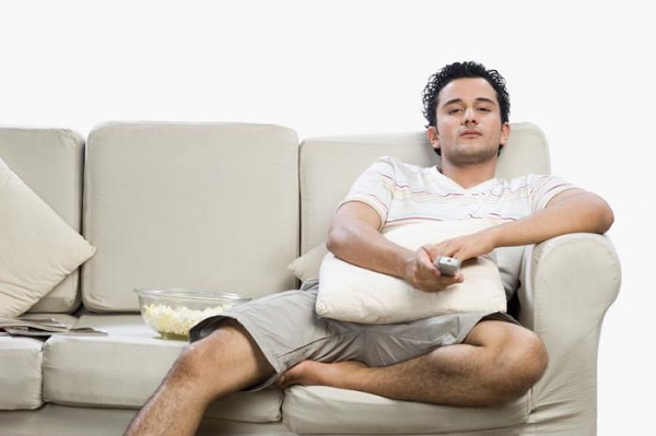 a-man-sitting-on-a-sofa-watching-tv